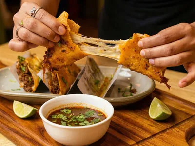 Birria tacos with melted cheese pull and consomme dipping sauce at Ixtapa Mexican Restaurant, Lunenburg MA