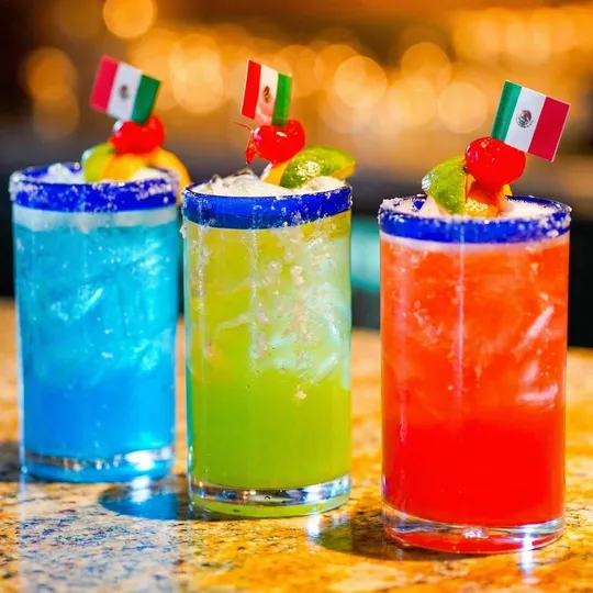 Three colorful margaritas with Mexican flags on granite bar at Ixtapa Cantina, Lunenburg MA